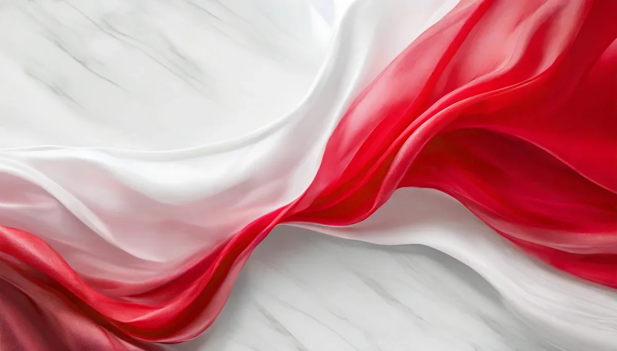 Falująca biało-czerwona tkanina ułożona na jasnym, marmurowym tle.