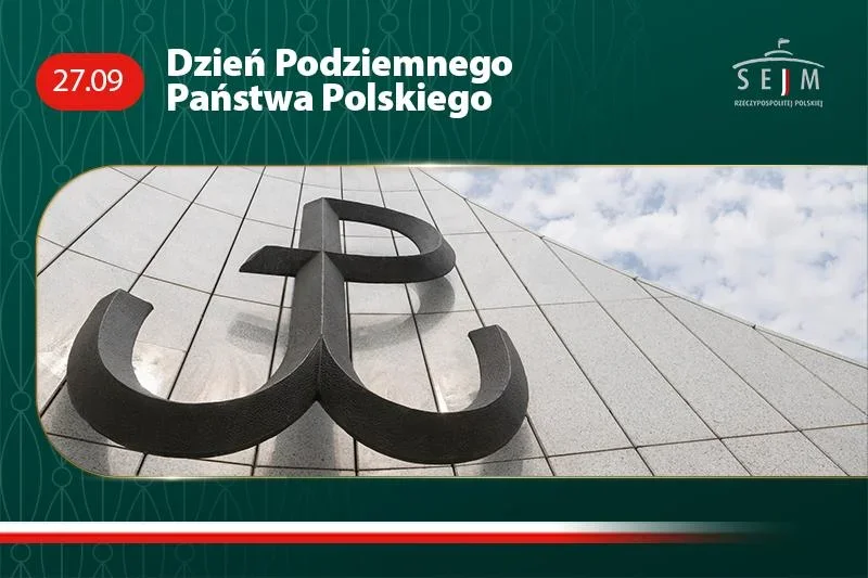 Metalowy znak Polski Walczącej na elewacji z jasnych płytek, sfotografowany z dołu pod błękitnym niebem z chmurami.