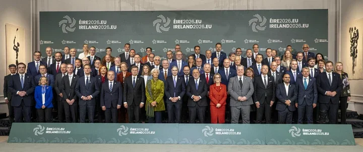 Uczestnicy spotkania formalnego pozują do grupowego zdjęcia przed ścianką z logo Ireland2026.eu.