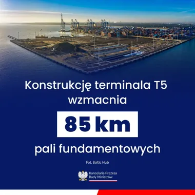 Widok z lotu ptaka na budowę terminala kontenerowego T5 w porcie, z głębokowodnym nabrzeżem, żurawiami i stosami kontenerów.