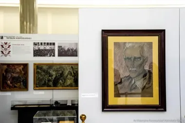 Wystawa historyczna w gmachu Sejmu: na pierwszym planie portret w ramie, w tle plansze i obrazy.