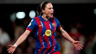 Piłkarka w barwach FC Barcelony świętuje z otwartymi ramionami na stadionie podczas meczu.