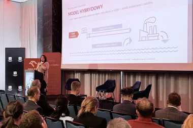 Kobieta wygłasza prezentację o modelu hybrydowym wykorzystania wody przed publicznością w sali konferencyjnej.