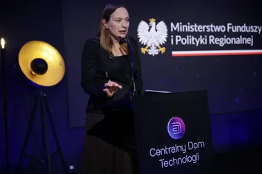 Kobieta przemawia z pulpitu podczas wydarzenia w Centralnym Domu Technologii, w tle logo Ministerstwa Funduszy i Polityki Regionalnej.